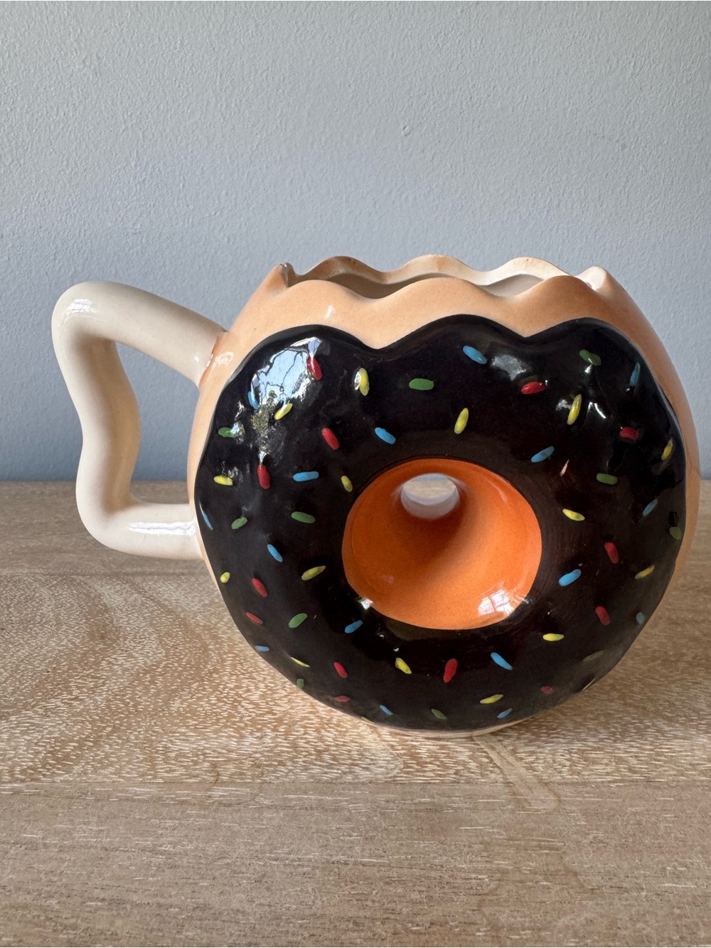 Donut-Shaped Ceramic Mug with Black Frosting and Tan Body